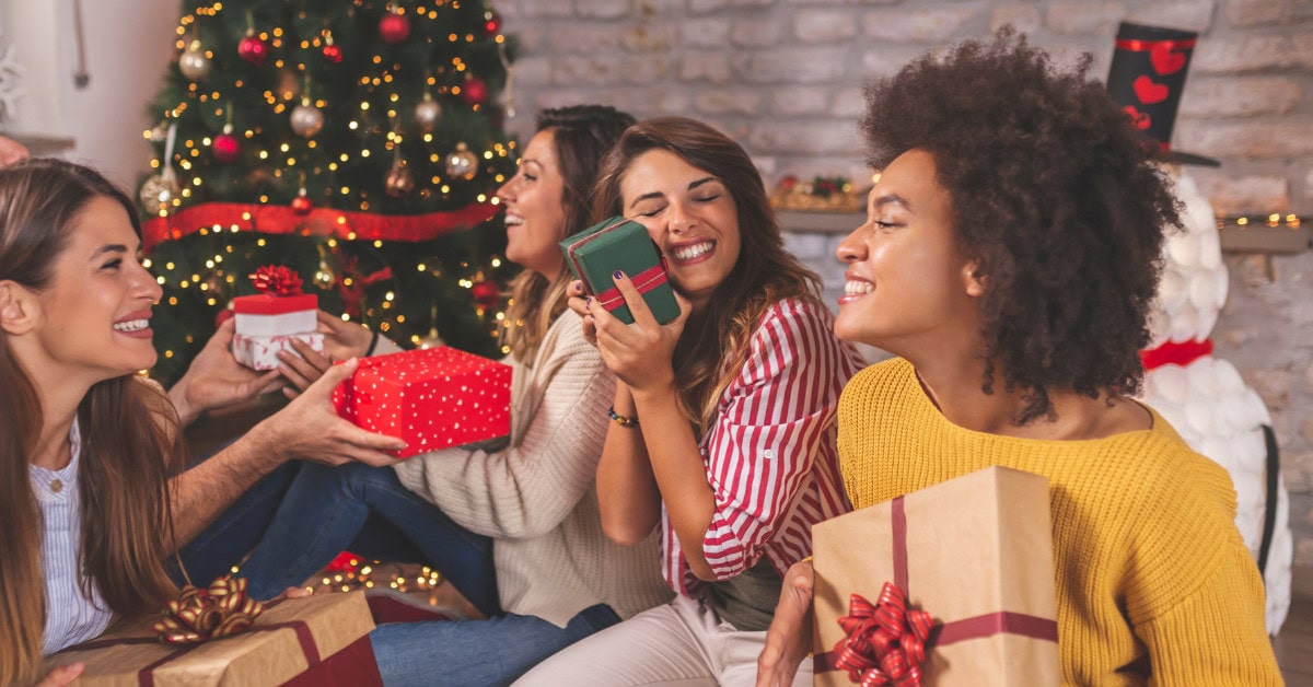 happy women receiving christmas gifts - $50 budget friendly gift guide