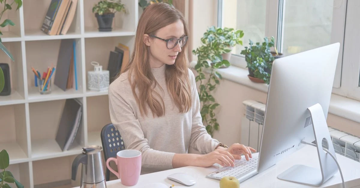 Pretty young woman working while looking at computer screen